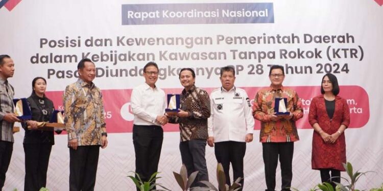 Wakil Gubernur (Wagub) Kalimantan Selatan, Hasnuryadi Sulaiman saat menerima plakat penghargaan terkait implementasi kawasan tanpa rokok (KTR)