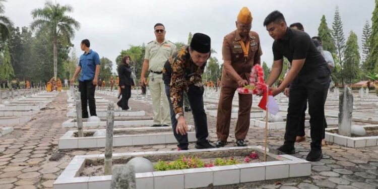 Wakil Gubernur Kalimantan Selatan, H Hasnuryadi Sulaiman saat menabur bunga di salah satu makam pahlawan di Taman Makam Pahlawan (TMP) Bumi Kencana Banjarbaru dalam rangkaian peringatan Hari Veteran Nasional ke-76 tahun 2025