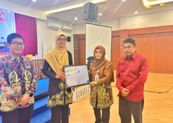 STAF Ahli Bidang Kemasyarakatan dan SDM Jurainah saat menyerahkan piagam penghargaankepada KPU dan Bawaslu Kotabaru, Kamis (21/8).