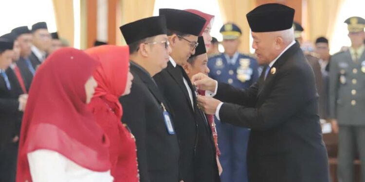 GUBERNUR Kalimantan Selatan, H Muhidin secara simbolis saat menyematkan tanda kehormatan satya lancana karya satya X, XX dan XXX dari Presiden kepada ASN di lingkungan Pemprov Kalsel, di Banjarmasin.