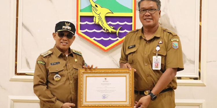 KADIS Pariwisata, Pemuda dan Olahraga Sonny Tua Halomoan saat menyerahkan piagam nasional dari Kemenparekraf RI kepada Bupati Kotabaru Muhammad Rusli, Senin (1/9).