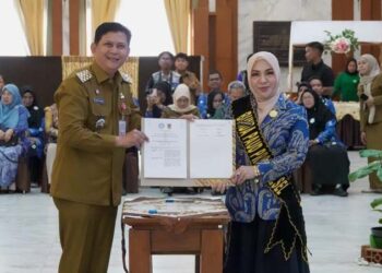 Bunda PAUD Provinsi Kalimantan Selatan, Hj Fathul Jannah saat menyerahkan nota kesepahaman terkait “Percepatan Kepemilikan Kartu Identitas Anak (KIA) bagi Anak Usia Dini pada Plt Kepala Dinas Kependudukan Pencatatan Sipil Provinsi Kalsel, Thaufik Hidayat