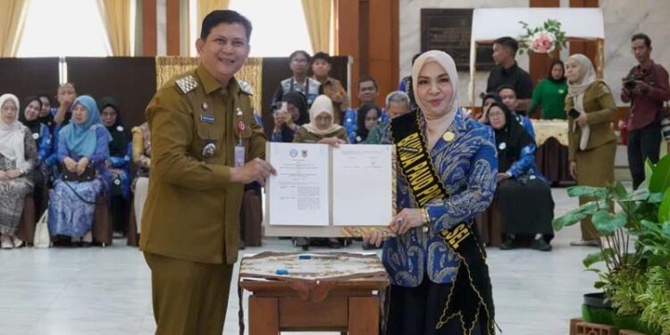 Bunda PAUD Provinsi Kalimantan Selatan, Hj Fathul Jannah saat menyerahkan nota kesepahaman terkait “Percepatan Kepemilikan Kartu Identitas Anak (KIA) bagi Anak Usia Dini pada Plt Kepala Dinas Kependudukan Pencatatan Sipil Provinsi Kalsel, Thaufik Hidayat