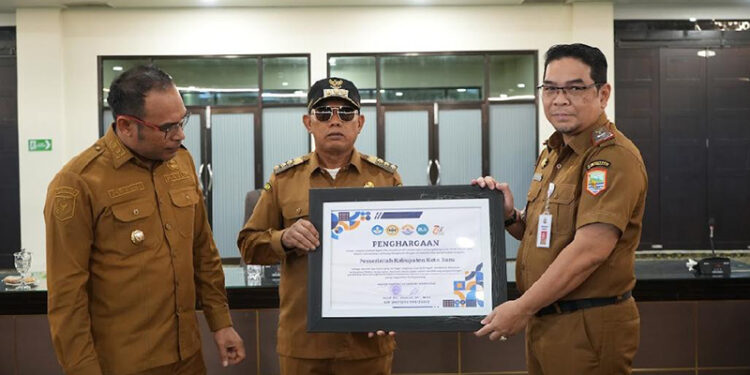 BUPATI Kotabaru Muhammad Rusli didampingi Wakil Bupati Syairi Mukhlis di Aula Bamega Setda Kotabaru saat menerima penghargaan yang diserahkan Sekretaris Daerah Eka Sapruddin, Senin (6/10).