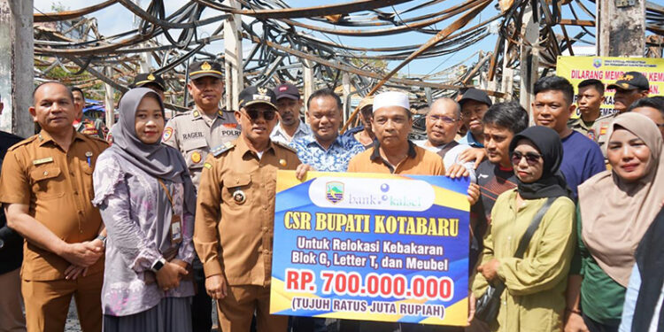 BUPATI Kotabaru H Muhammad Rusli saat menyerahkan bantuan CSR Bank Kalsel kepada 167 kios pedagang terdampak musibah kebakaran di Pasar Kemakmuran, Selasa (7/10).