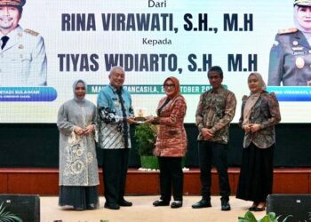 Gubernur Kalimantan Selatan, H Muhidin didampingi isteri, Hj Fathul Jannah saat menyerahkan cinderamata kepada Rina Verawati (mantan Kejati Kalsel) disela pisah sambut di Banjarmasin