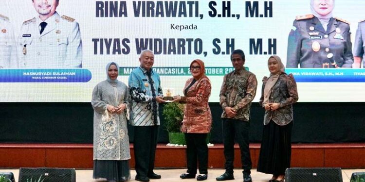 Gubernur Kalimantan Selatan, H Muhidin didampingi isteri, Hj Fathul Jannah saat menyerahkan cinderamata kepada Rina Verawati (mantan Kejati Kalsel) disela pisah sambut di Banjarmasin