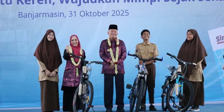 Gubernur Kalimantan Selatan, H Muhidin didampingi isteri, Hj Fathul Jannah berfoto bersama siswa Ukhuwah Banjarmasin yang menerima hadiah sepeda pada puncak Bulan Inklusi Keuangan Tahun 2025, di Gedung Ukhuwah Banjarmasin