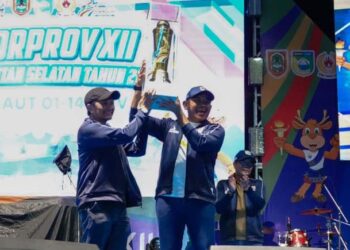 Wakil Gubernur (Wagub) Kalimantan Selatan, Hasnuryadi Sulaiman saat menyerahkan tropi bergilir juara umum Porprov Kalsel tahun 2025 diterima Bupati Tanah Laut (Tala), H Rahmat Trianto pada penutupan Porprov XII Kalsel, di Pelaihari