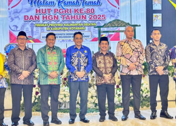 KETUA PGRI Kalsel H Abdul Rivai bersama Asisten III Bidang Administrasi Umum Setda Kotabaru Selamat Riyadi berfoto bersama pada malam ramah tamah dalam rangka memperingati HUT ke-80 PGRI dan HGN Tahun 2025 di Gedung Paris Barantai, Minggu (7/12) malam.