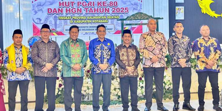 KETUA PGRI Kalsel H Abdul Rivai bersama Asisten III Bidang Administrasi Umum Setda Kotabaru Selamat Riyadi berfoto bersama pada malam ramah tamah dalam rangka memperingati HUT ke-80 PGRI dan HGN Tahun 2025 di Gedung Paris Barantai, Minggu (7/12) malam.