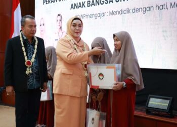 Ketua Ketua DWP Provinsi Kalimantan Selatan, Ny Masrupah saat menyerahkan bantuan peralatan sekolah untuk anak-anak aparatur sipil negara (ASN) di lingkungan Pemprov Kalsel, disaksikan Sekdaprov Kalsel, HM Syarifuddin, MPd