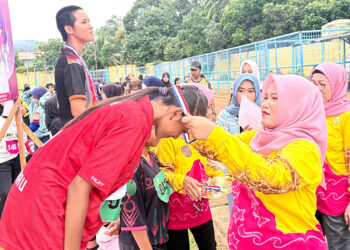 PENASIHAT Perwosi Kotabaru Suci Anisa Rusli saat mengalungkan medali kepada salah satu pemenang Kejuaraan Atletik Wanita Tingkat SMP/SMA Sederajat dan Perguruan Tinggi di Lapangan Stadion Bamega, Minggu (14/12).