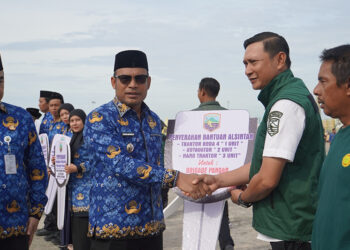 WABUP Kotabaru Syairi Mukhlis saat menyerahkan batuan alsintan usai memimpin Apel Hari Kesadaran Nasional di Lapangan Siring Laut, Rabu (17/12).