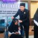 Wakil Gubernur (Wagub) Kalimantan Selatan, H Hasnuryadi Sulaiman ketika mengalungkan tanda peserta pada salah satu peserta rehabilitasi bagi penyandang disabilitas di Kalsel