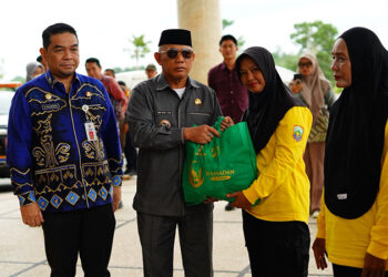 BUPATI Kotabaru H Muhammad Rusli saat menyerahkan paket sembako kepada petugas lapangan DLH.