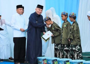 GUBERNUR Kalimantan Selatan H Muhidin saat menyerahkan bingkisan pada sejumlah anak yatim, disela silaturrahmi dan berbuka puasa bersama Pangdam XXII Tambun Bungai, Mayjen TNI Zainul Arifin, di Makorem 101 Antasari di Banjarmasin.