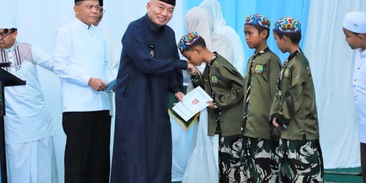 GUBERNUR Kalimantan Selatan H Muhidin saat menyerahkan bingkisan pada sejumlah anak yatim, disela silaturrahmi dan berbuka puasa bersama Pangdam XXII Tambun Bungai, Mayjen TNI Zainul Arifin, di Makorem 101 Antasari di Banjarmasin.