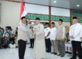 Gubernur Kalimantan Selatan, H Muhidin saat menyerahkan bendera Mrah Putih kepada pimpinan rombongan Kloter 1 Embarkasi Haji Banjarmasin sebagai tanda dilepasnya calon jemaah haji (CJH) asal Kalsel di Asrama Haji Banjarmasin, di Banjarbaru