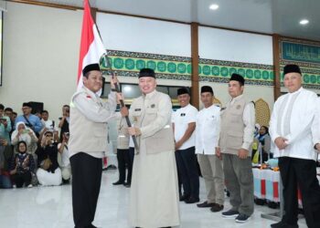 Gubernur Kalimantan Selatan, H Muhidin saat menyerahkan bendera Mrah Putih kepada pimpinan rombongan Kloter 1 Embarkasi Haji Banjarmasin sebagai tanda dilepasnya calon jemaah haji (CJH) asal Kalsel di Asrama Haji Banjarmasin, di Banjarbaru