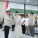 Gubernur Kalimantan Selatan, H Muhidin saat menyerahkan bendera Mrah Putih kepada pimpinan rombongan Kloter 1 Embarkasi Haji Banjarmasin sebagai tanda dilepasnya calon jemaah haji (CJH) asal Kalsel di Asrama Haji Banjarmasin, di Banjarbaru