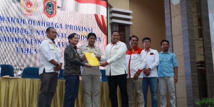 WAKIL Gubernur (Wagub) Kalimantan Selatan, H Hasnuryadi Sulaiman saat menerima amanah untuk memimpin KONI Kalsel lima tahun kedepan yang diserahkan Ketua Umum KONI Provinsi Kalsel periode 2015-2026, H Bambang Heri Purnama, disela Musyawarah Olahraga Provinsi (Musorprov) KONI Provinsi Kalimantan Selatan 2026.