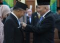 Gubernur Kalimantan Selatan, H Muhidin ketika menyematkan Satya Lancana Karya Satya 30 tahun kepada Sekdaprov Kalsel, H Muhammad Syarifuddin