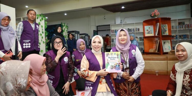 Ketua Tim Pembina (TP) Posyandu Provinsi Kalimantan Selatan, Hj Fathul Jannah Muhidin menyerahkan buku bacaan untuk anak disela sosialisasi 6 SPM di Kabupaten Tabalong