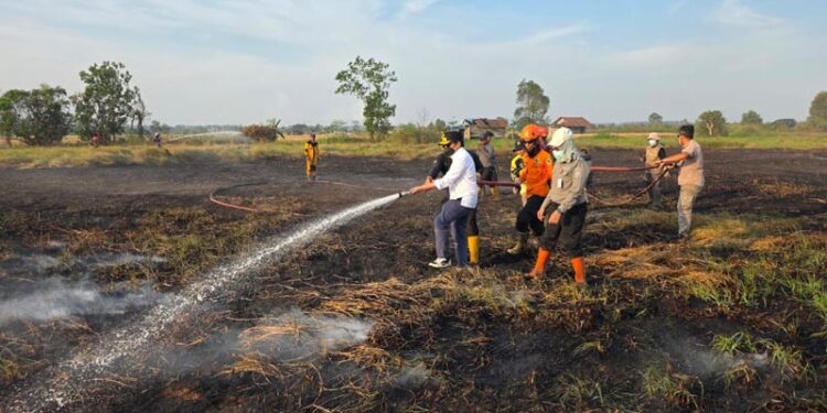 Wakil Gubernur (Wagub) Kalimantan Selatan, H Hasnuryadi Sulaiman saat ikut menyemprotkan air ke lokasi lahan yang masih terbakar, di Pengayuan, Banjarbaru