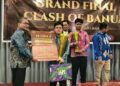 Staf Ahli Gubernur Bidang Ekonomi dan Pembangunan, Rusma Khazairin saat menyerahkan piala da penghargaan kepada juara I dalam Lomba Cerdas Cermat Clash of Banua Tingkat SMA/SMK se-Kalimantan Selatan Tahun 2026
