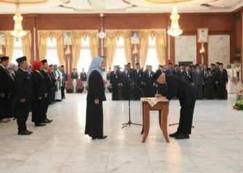 GUBERNUR Kalimantan Selatan H Muhidin saat menandatangani berita acara pelantikan kepala sekolah dan pejabat fungsional di lingkungan Pemprov Kalsel.