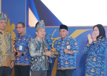 Sekdaprov Kalimantan Selatan, HM Syarifuddin saat menyerahkan penghargaan kepada Kepala Dinas Kelautan dan Perikanan Provinsi Kalsel, Rusdi Hartono sebagai terbaik I dalam penganugerahan Geospasial Award 2026 untuk katagori SKPD provinsi