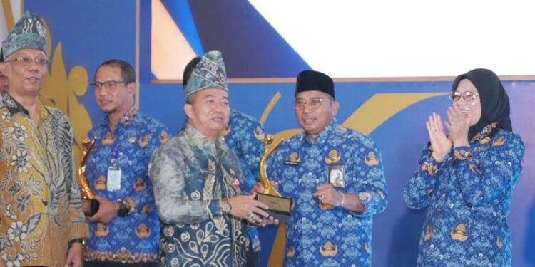 Sekdaprov Kalimantan Selatan, HM Syarifuddin saat menyerahkan penghargaan kepada Kepala Dinas Kelautan dan Perikanan Provinsi Kalsel, Rusdi Hartono sebagai terbaik I dalam penganugerahan Geospasial Award 2026 untuk katagori SKPD provinsi