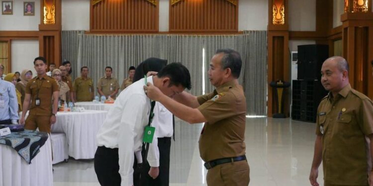 Sekdaprov Kalimantan Selatan, HM Syarifuddin saat mengalungkan tanda peserta pada uji kompetensi Aparatur Pengelolaan Keuangan Daerah Angkatan I sampai V dan Uji Kompetensi Pemerintahan Jabatan Pengawas Angkatan I tahun 2026